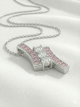 Primer plano (macro) del engaste de zirconias rosas y blancas. Se aprecia la calidad del brillo y el acabado pulido espejo de la plata.